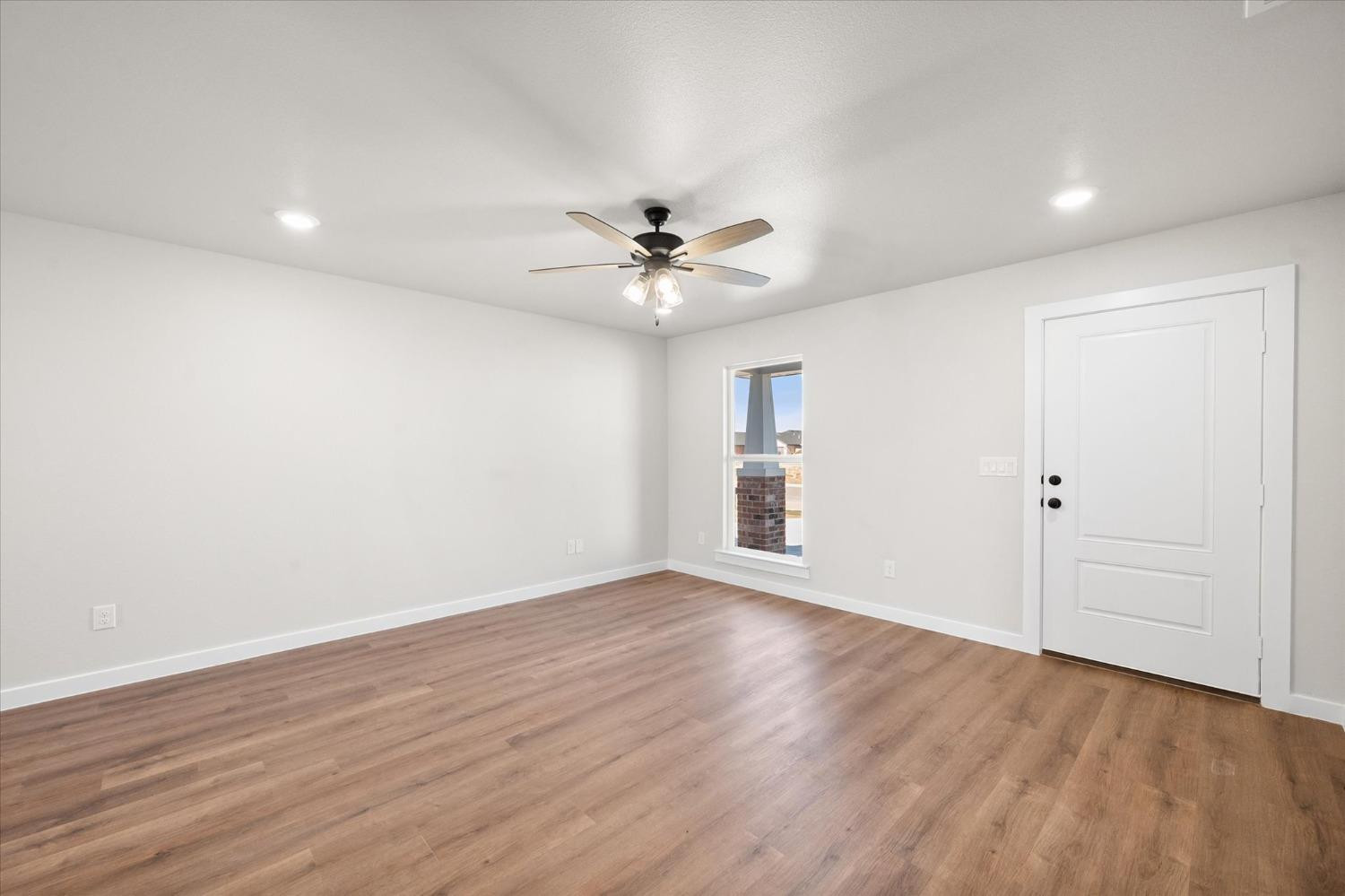 5519 Queens Street Lubbock, TX 79416 - Photo 7 of 21 an empty room with wooden floor and ceiling fan