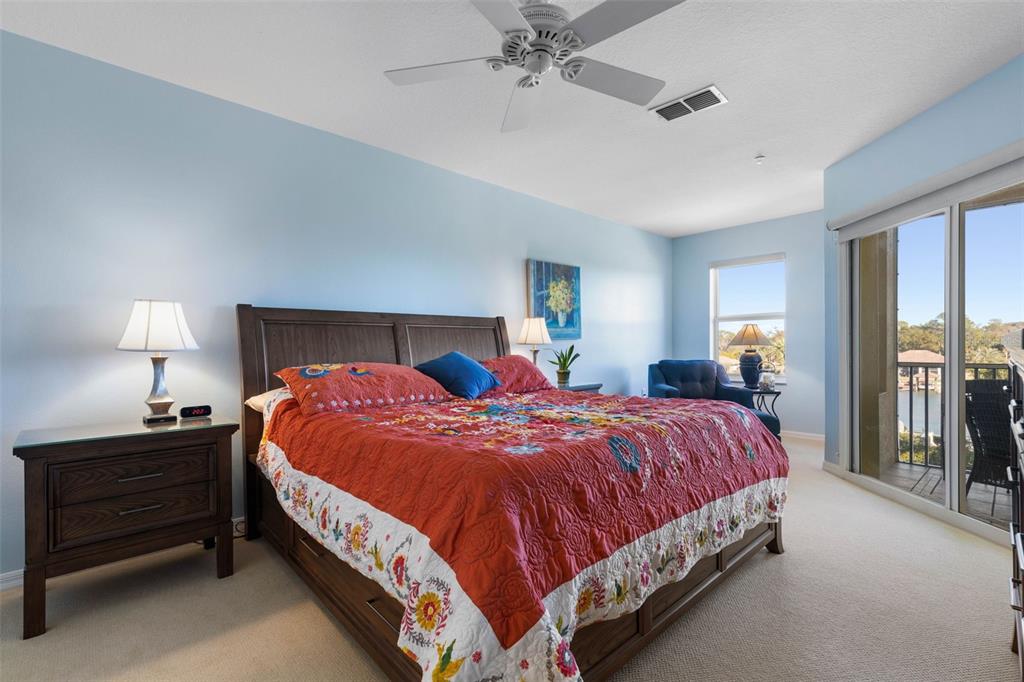 700 Canopy Walk Lane, Unit 735 Palm Coast, FL 32137 - Photo 29 of 77 a bedroom with a bed and a lamp
