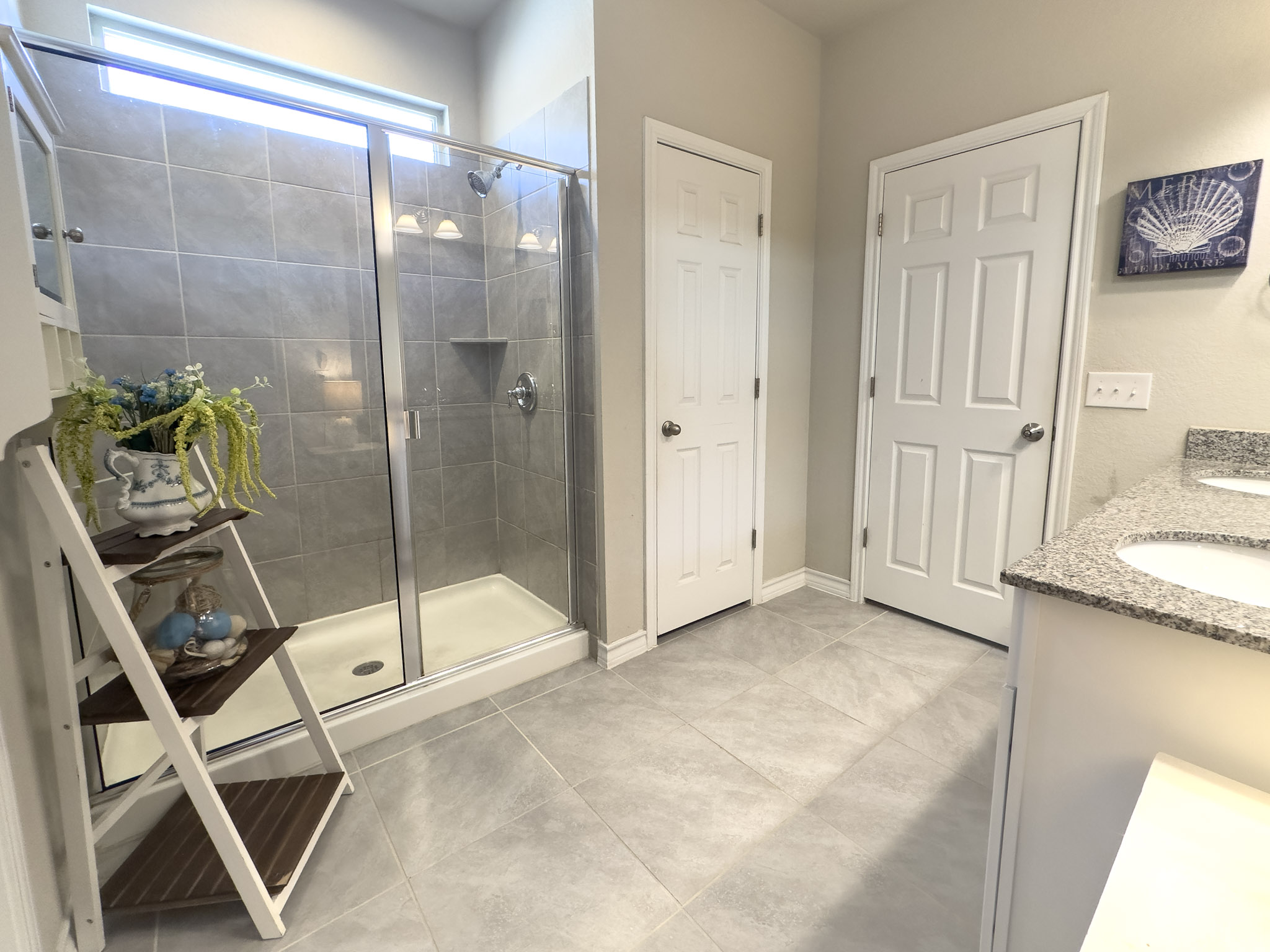 11005 Players Path Austin, TX 78747 - Photo 15 of 40 Full bath featuring a stall shower, double vanity, and light tile patterned flooring