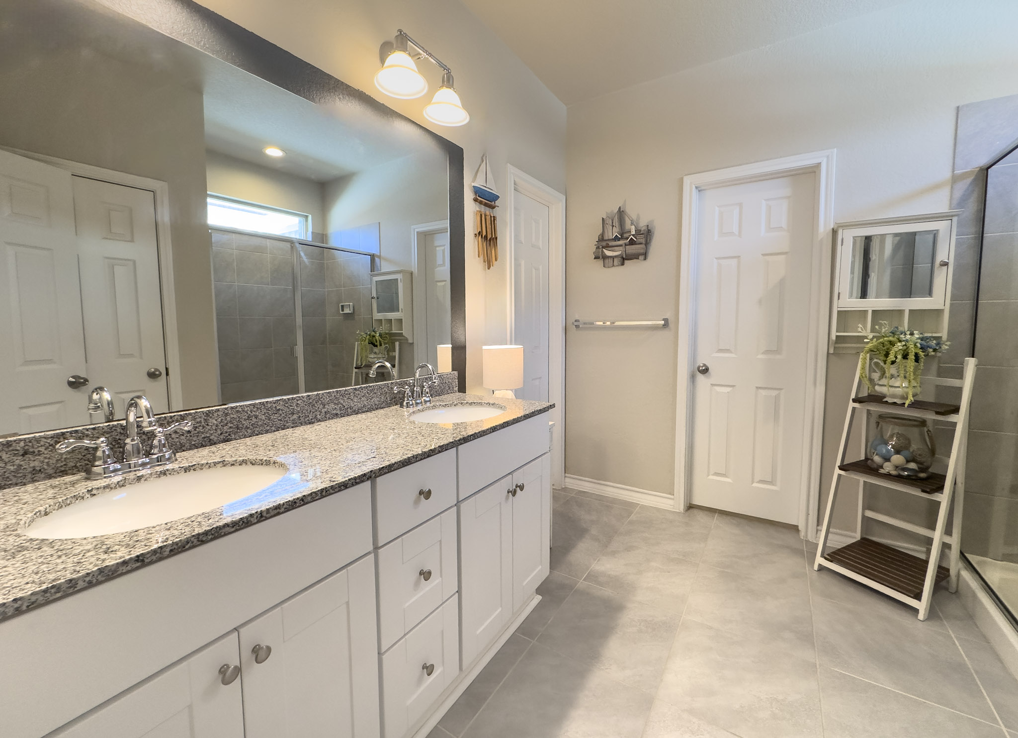 11005 Players Path Austin, TX 78747 - Photo 16 of 40 Bathroom featuring a shower stall, double vanity, and light tile patterned flooring