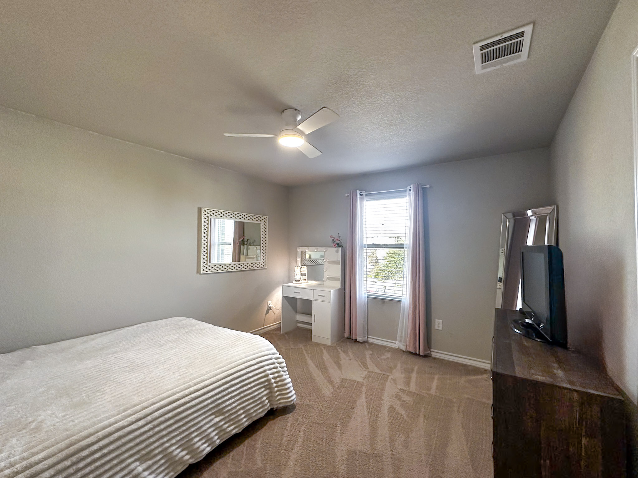 11005 Players Path Austin, TX 78747 - Photo 26 of 40 Bedroom with light carpet, a ceiling fan, and a textured ceiling