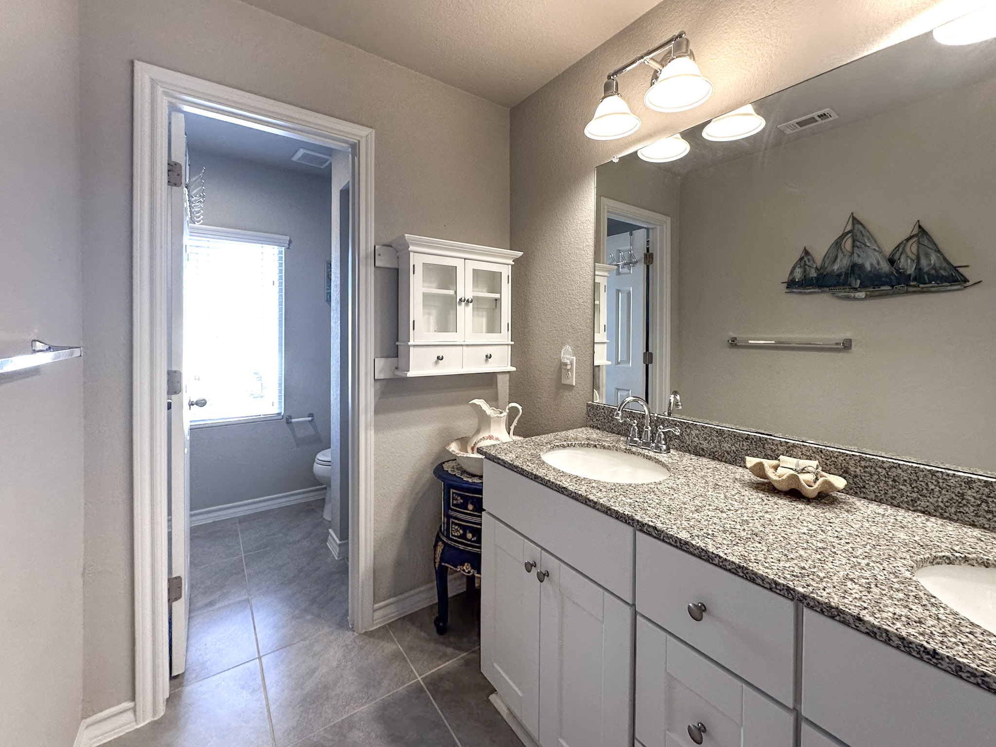 11005 Players Path Austin, TX 78747 - Photo 29 of 40 Bathroom with double vanity, a textured wall, and dark tile patterned floors