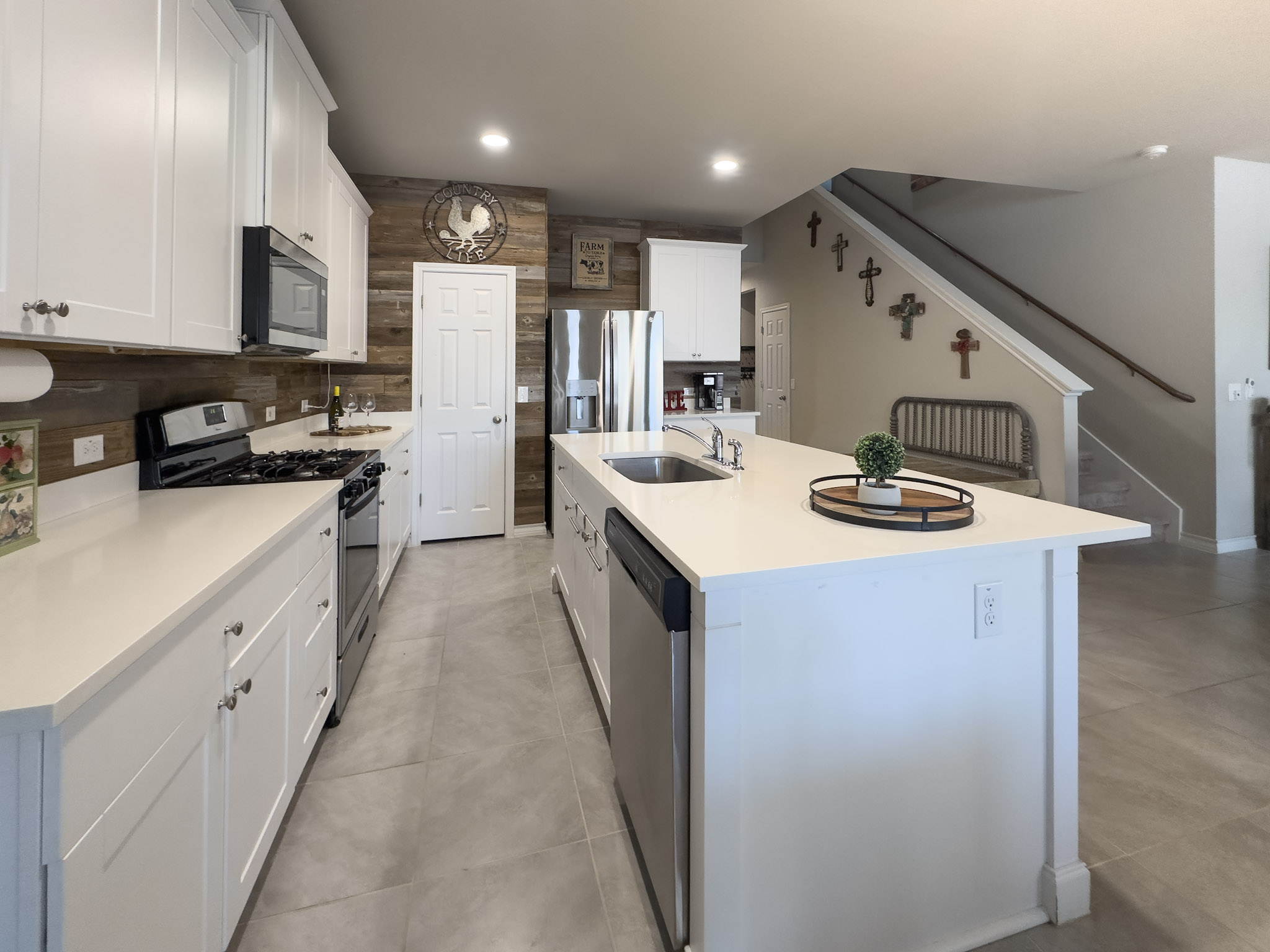 11005 Players Path Austin, TX 78747 - Photo 2 of 40 Kitchen with stainless steel appliances, a kitchen island with sink, white cabinets, recessed lighting, and light stone counters