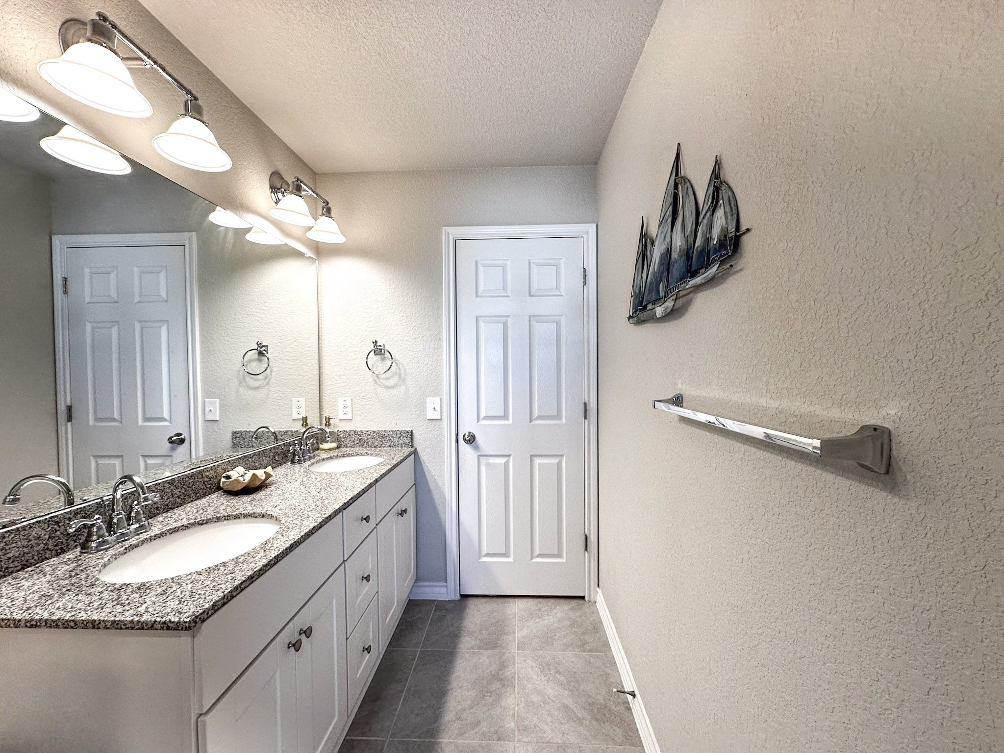 11005 Players Path Austin, TX 78747 - Photo 30 of 40 Bathroom with a textured wall, double vanity, a textured ceiling, and dark tile patterned flooring