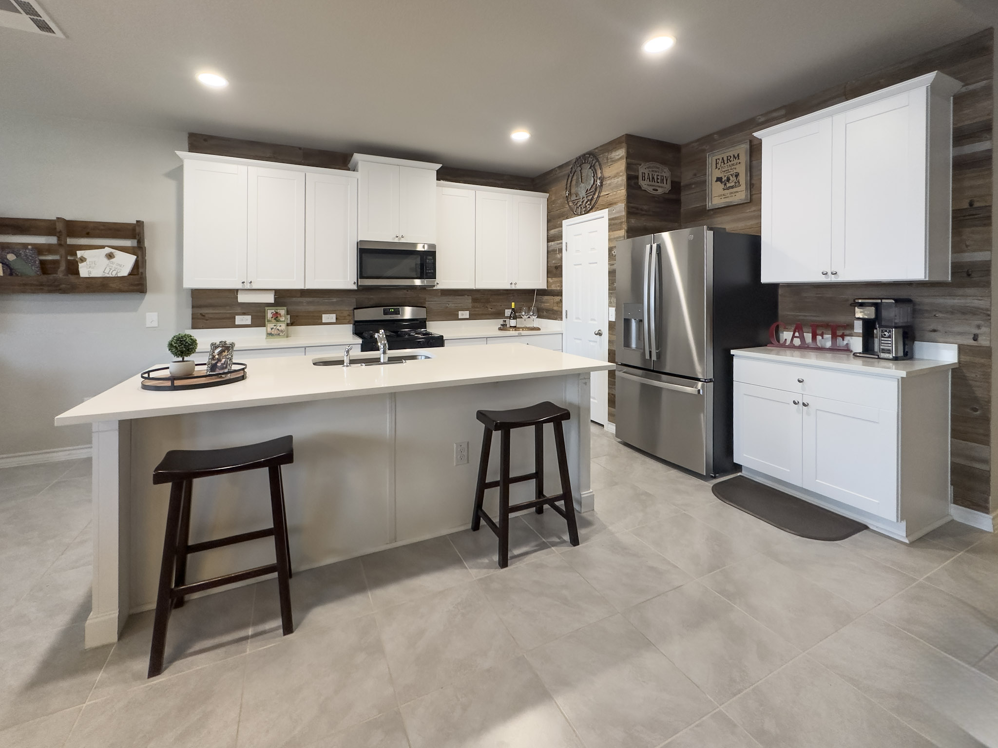 11005 Players Path Austin, TX 78747 - Photo 4 of 40 Kitchen with a breakfast bar area, stainless steel appliances, an island with sink, white cabinetry, and recessed lighting