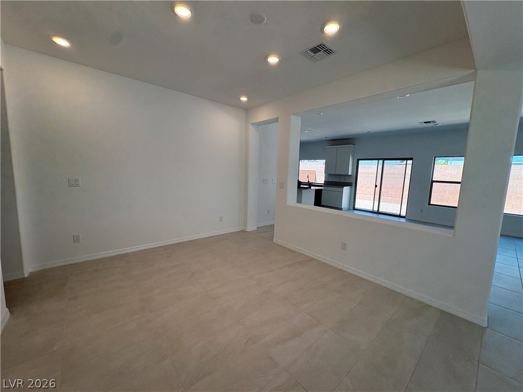 8677 South Indigo Springs Road Las Vegas, NV 89139 - Photo 2 of 9 Recessed lighting illuminates this versatile space, featuring sleek tile flooring and a seamless transition to the kitchen area.