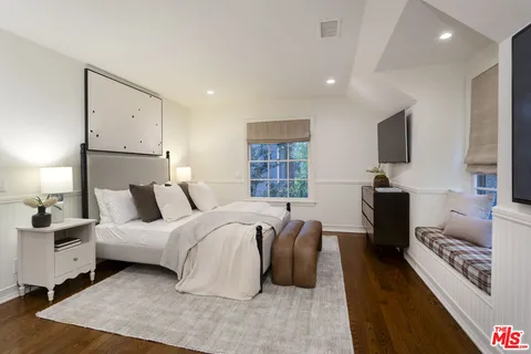 a spacious bedroom with a bed and a flat screen television