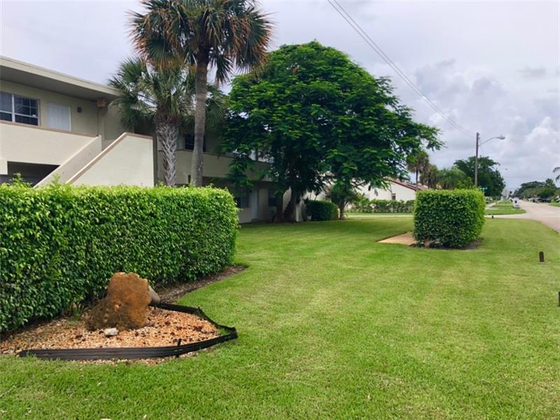 4670 Northeast 5th Avenue, Unit 9 Boca Raton, FL 33431 - Photo 2 of 8 a front view of a house with a yard