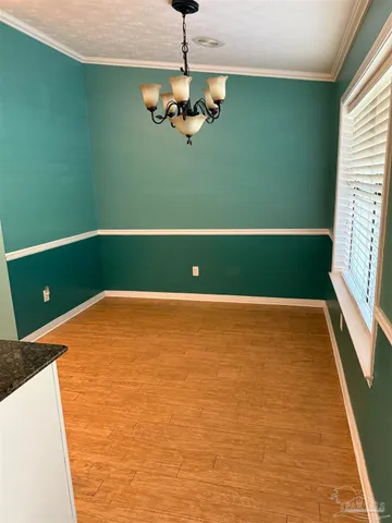 a view of a room with window wooden floor and front door