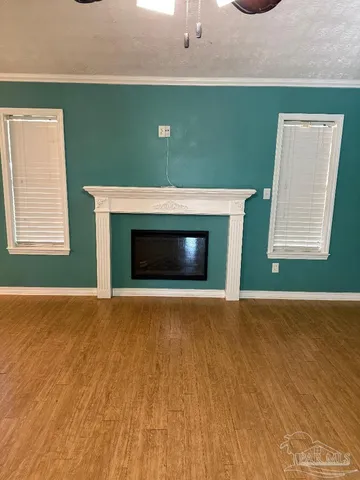 a view of an empty room with a fireplace and a window