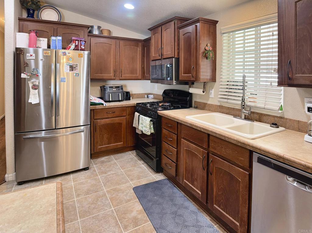 9395 Harritt Road, Unit 215 Lakeside, CA 92040 - Photo 11 of 27 a kitchen with stainless steel appliances granite countertop a refrigerator sink and cabinets