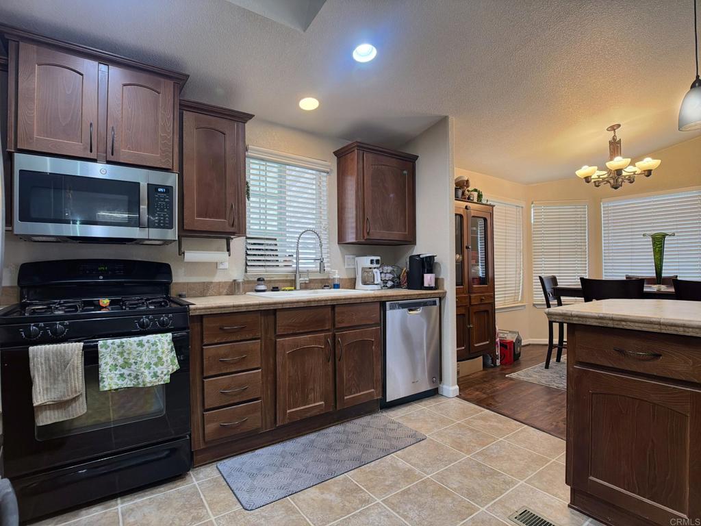 9395 Harritt Road, Unit 215 Lakeside, CA 92040 - Photo 12 of 27 a kitchen with a sink cabinets and stainless steel appliances