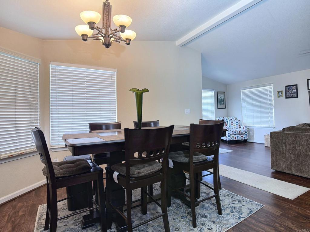 9395 Harritt Road, Unit 215 Lakeside, CA 92040 - Photo 15 of 27 a view of a dining room with furniture a chandelier and wooden floor