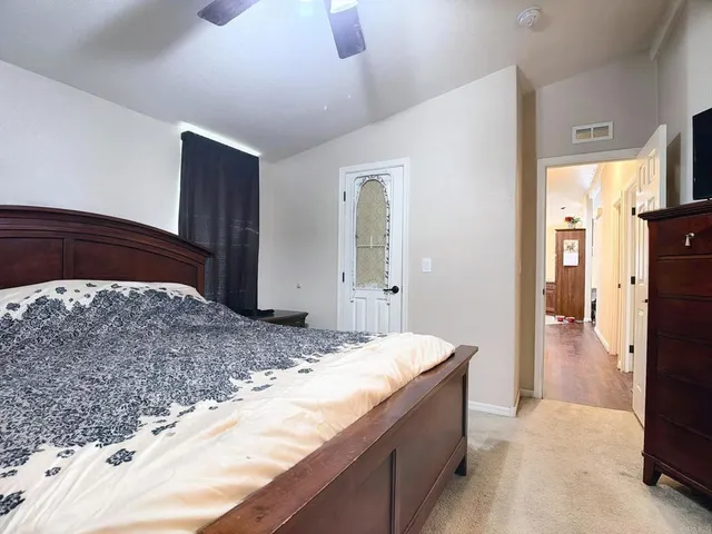 a spacious bedroom with a bed and a dresser