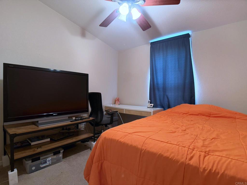 9395 Harritt Road, Unit 215 Lakeside, CA 92040 - Photo 24 of 27 a bedroom with a bed and a flat screen tv