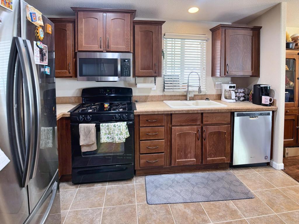9395 Harritt Road, Unit 215 Lakeside, CA 92040 - Photo 10 of 27 a kitchen with stainless steel appliances granite countertop a stove a refrigerator and a sink