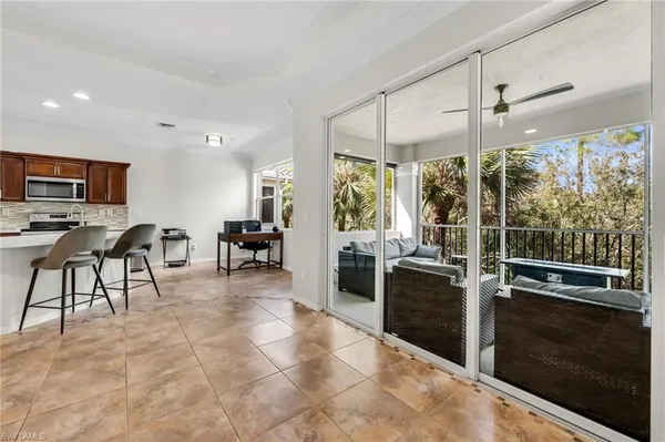 a kitchen with stainless steel appliances granite countertop a stove top oven a sink a dining table and chairs