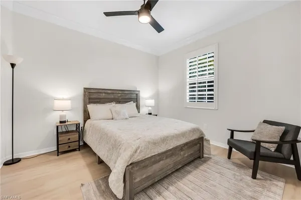 a large bed sitting in a bedroom next to a window and a chair