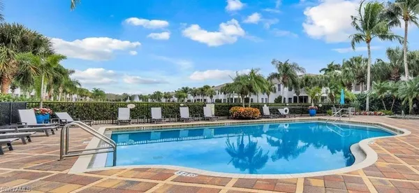 a view of a swimming pool with a lounge chair and palm trees