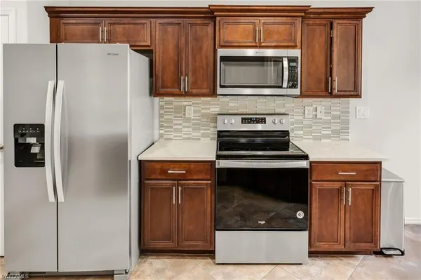a kitchen with granite countertop a refrigerator and a stove top oven