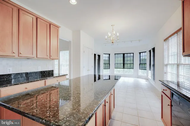 a large kitchen with kitchen island granite countertop a large window