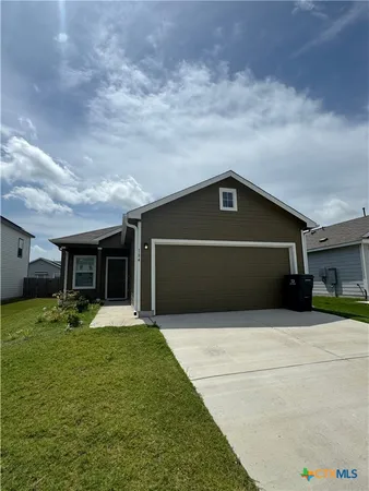 a front view of house with yard and garage