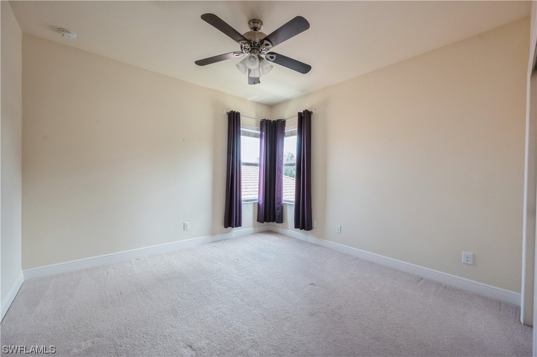 19658 Tesoro Way Estero, FL 33967 - Photo 20 of 25 an empty room with a ceiling fan and window