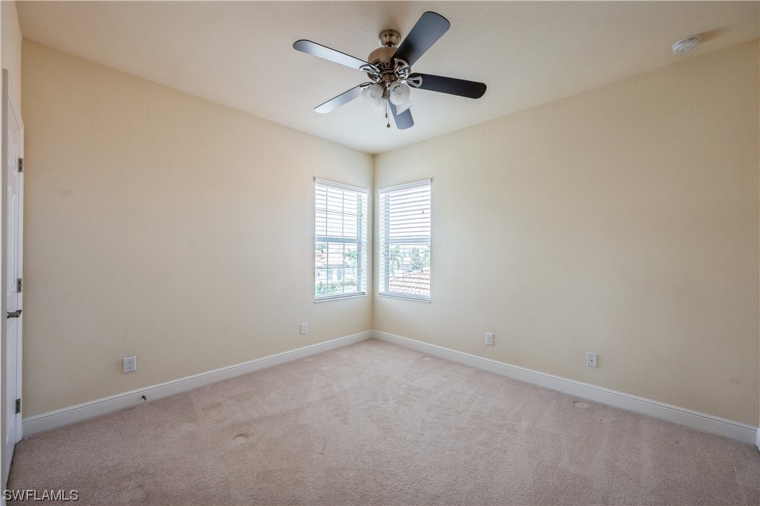 19658 Tesoro Way Estero, FL 33967 - Photo 21 of 25 an empty room with a window and a ceiling fan