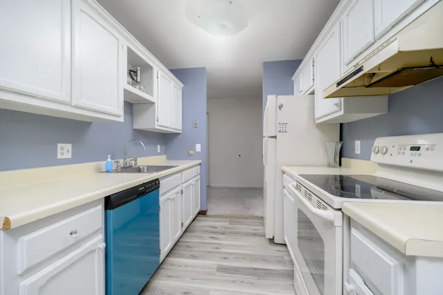 a kitchen with a sink a stove and cabinets