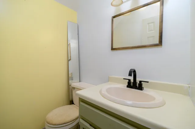 a bathroom with a sink a toilet and mirror