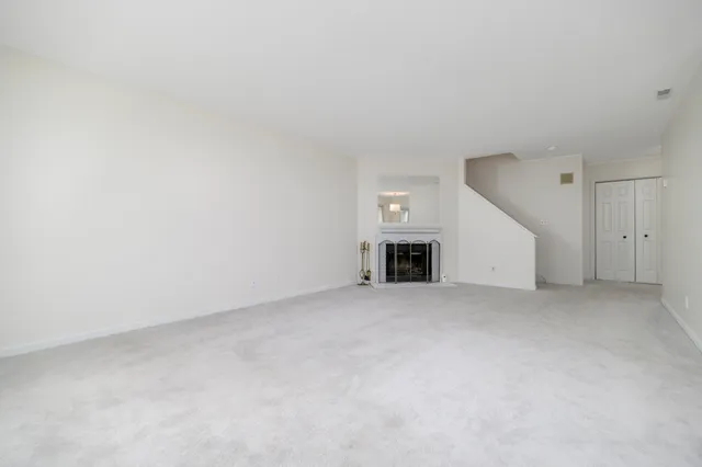 an empty room with a fireplace and a window