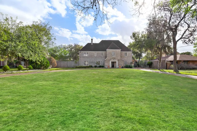 a large house with a big yard and large trees