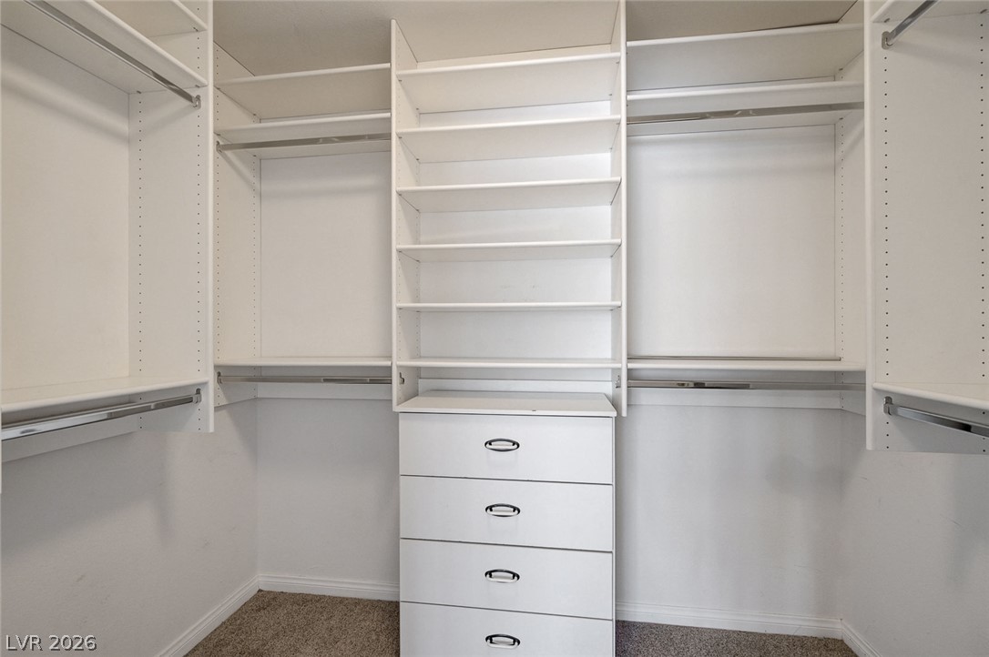 1479 Orange Jubilee Road Henderson, NV 89014 - Photo 22 of 36 Ample storage solutions await in this naturally illuminated walk-in closet with built-in shelving and drawers.