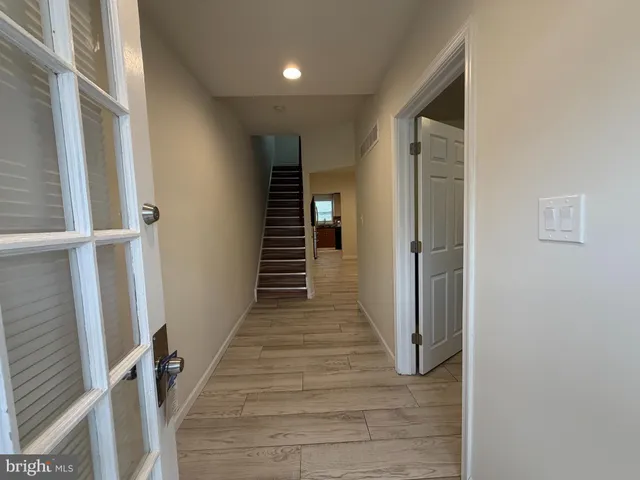 a view of a hallway with wooden floor and staircase