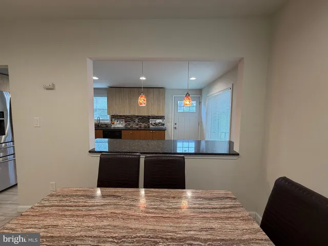 a view of kitchen with kitchen island microwave and stove top oven