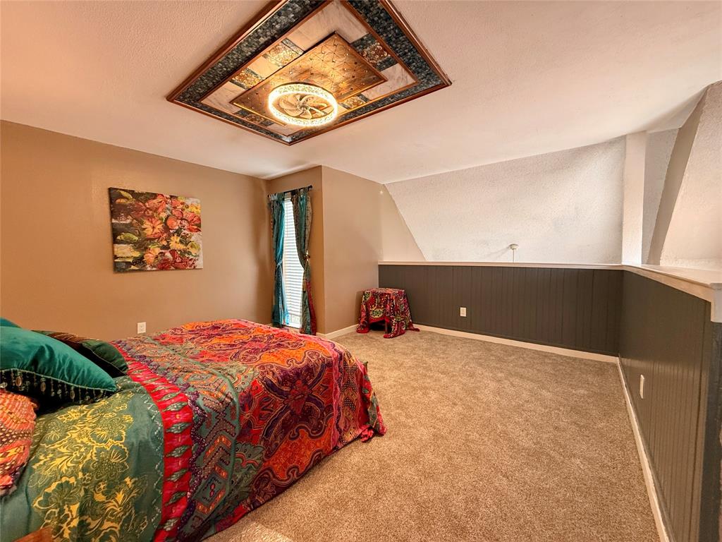 9807 Walnut Street, Unit D205 Dallas, TX 75243 - Photo 13 of 20 a bedroom with a bed and painting on the wall