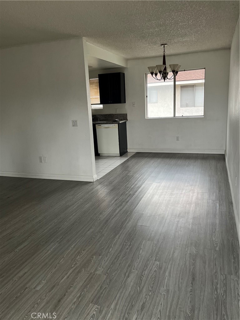 3073 Gladstone Street, Unit 4 Pomona, CA 91767 - Photo 5 of 10 an empty room with wooden floor and windows