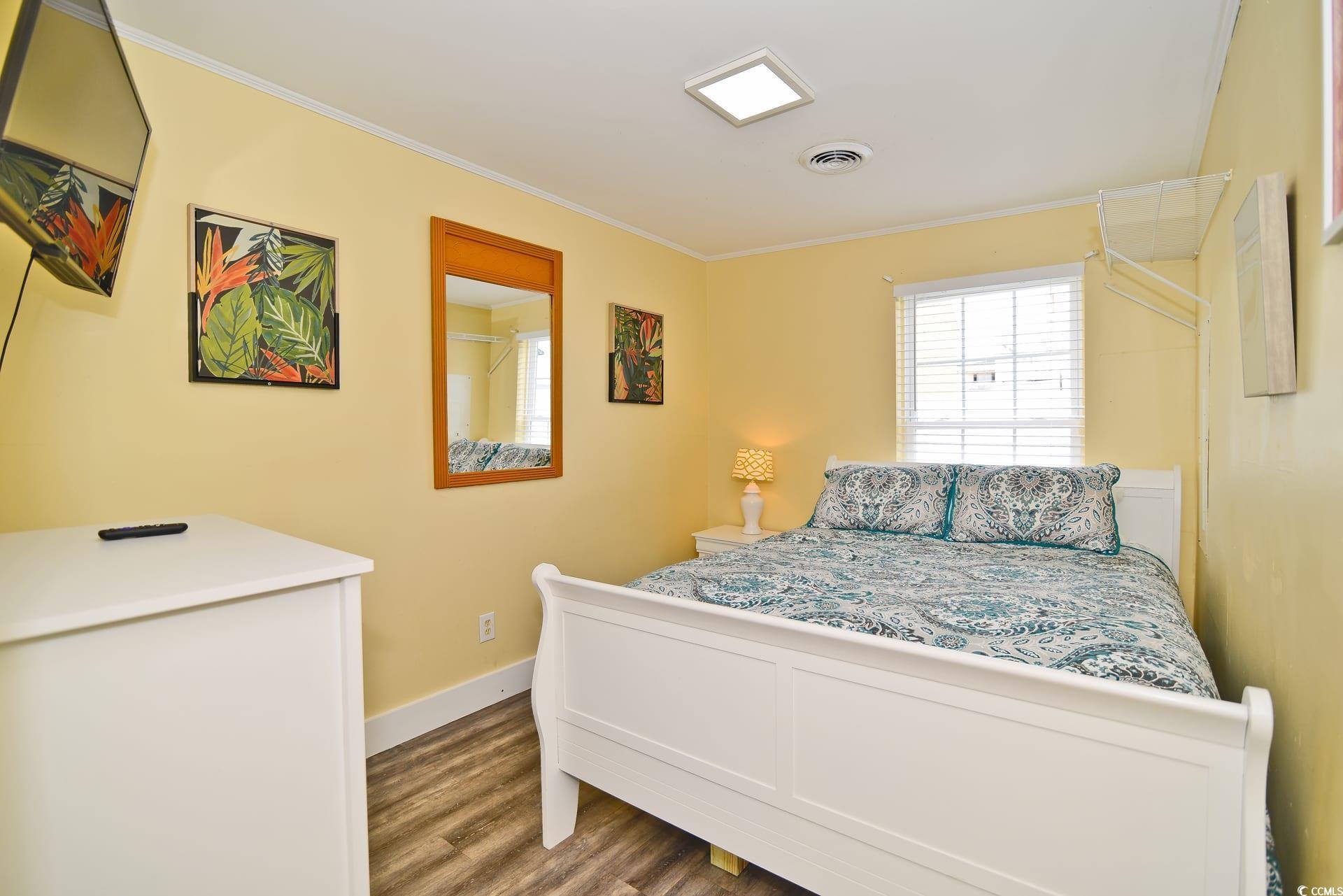 219 27th Avenue North North Myrtle Beach, SC 29582 - Photo 22 of 34 Bedroom with visible vents, baseboards, crown molding, and wood finished floors