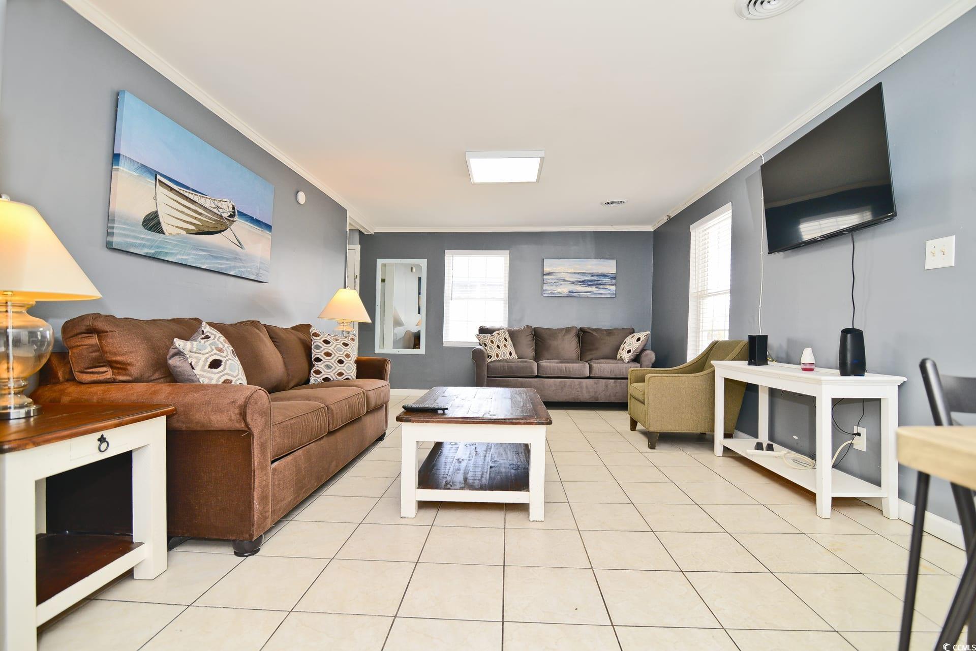 219 27th Avenue North North Myrtle Beach, SC 29582 - Photo 3 of 34 Living room featuring ornamental molding and light tile patterned floors