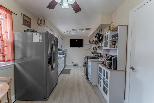 a kitchen with stainless steel appliances granite countertop a refrigerator and a stove