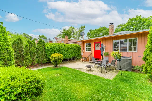 a view of a chair and table in backyard of the house