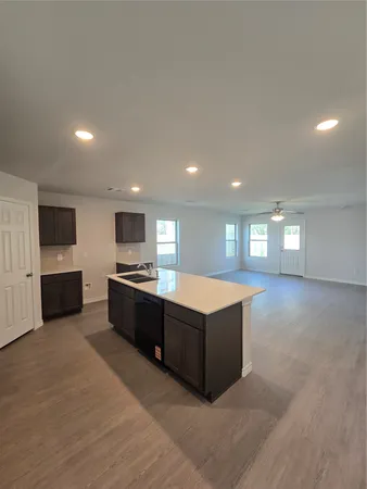 a large kitchen with stainless steel appliances a large counter top a stove and a refrigerator