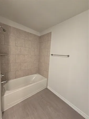 a white bath tub sitting next to a white sink and vanity