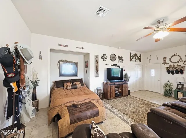 a bedroom with a bed and a tv on the dresser
