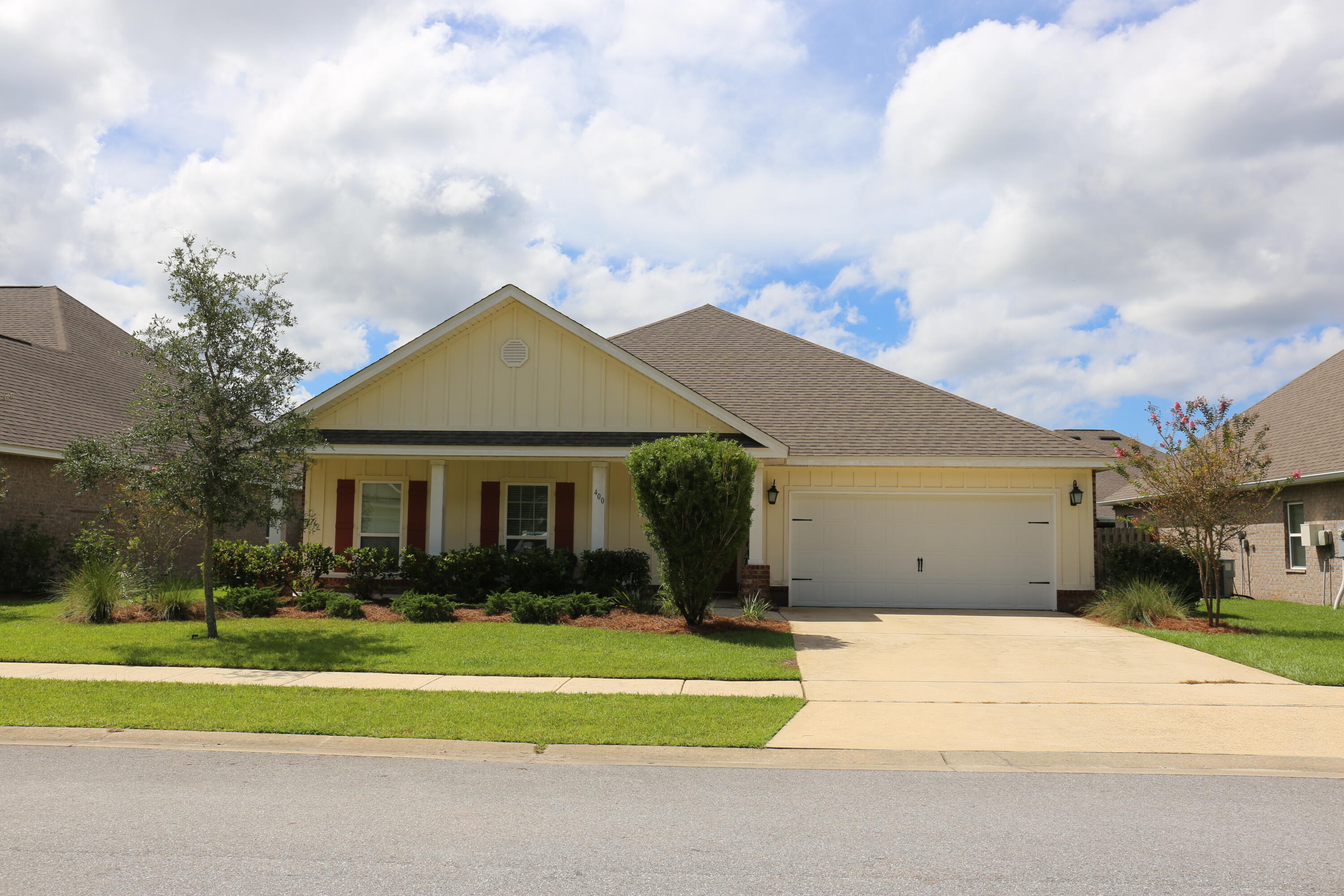 400 Lilly Bell Lane, Unit LOT 26 Freeport, FL 32439 - Photo 3 of 43 a front view of a house with a garden and trees