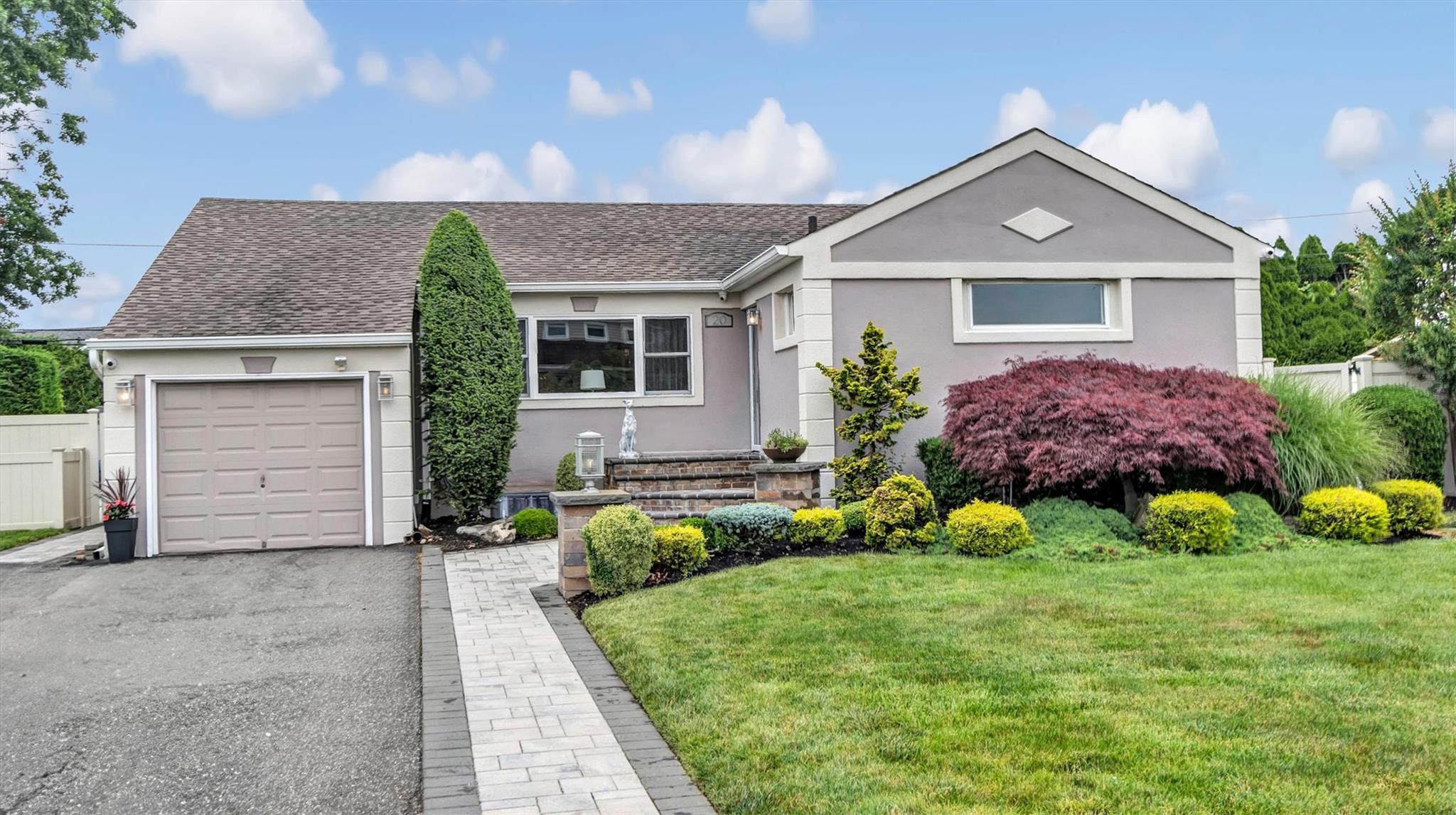Ranch-style house with a garage, stucco siding, and roof with shingles