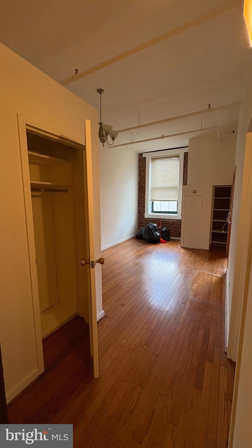 1010 Race Street, Unit 5I Philadelphia, PA 19107 - Photo 2 of 11 an empty room with wooden floor and a window