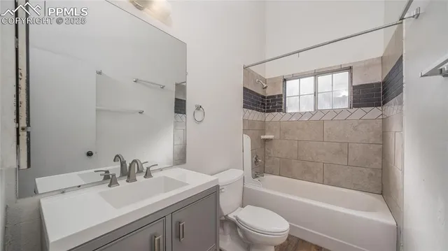 a bathroom with a bathtub shower sink vanity mirror and toilet