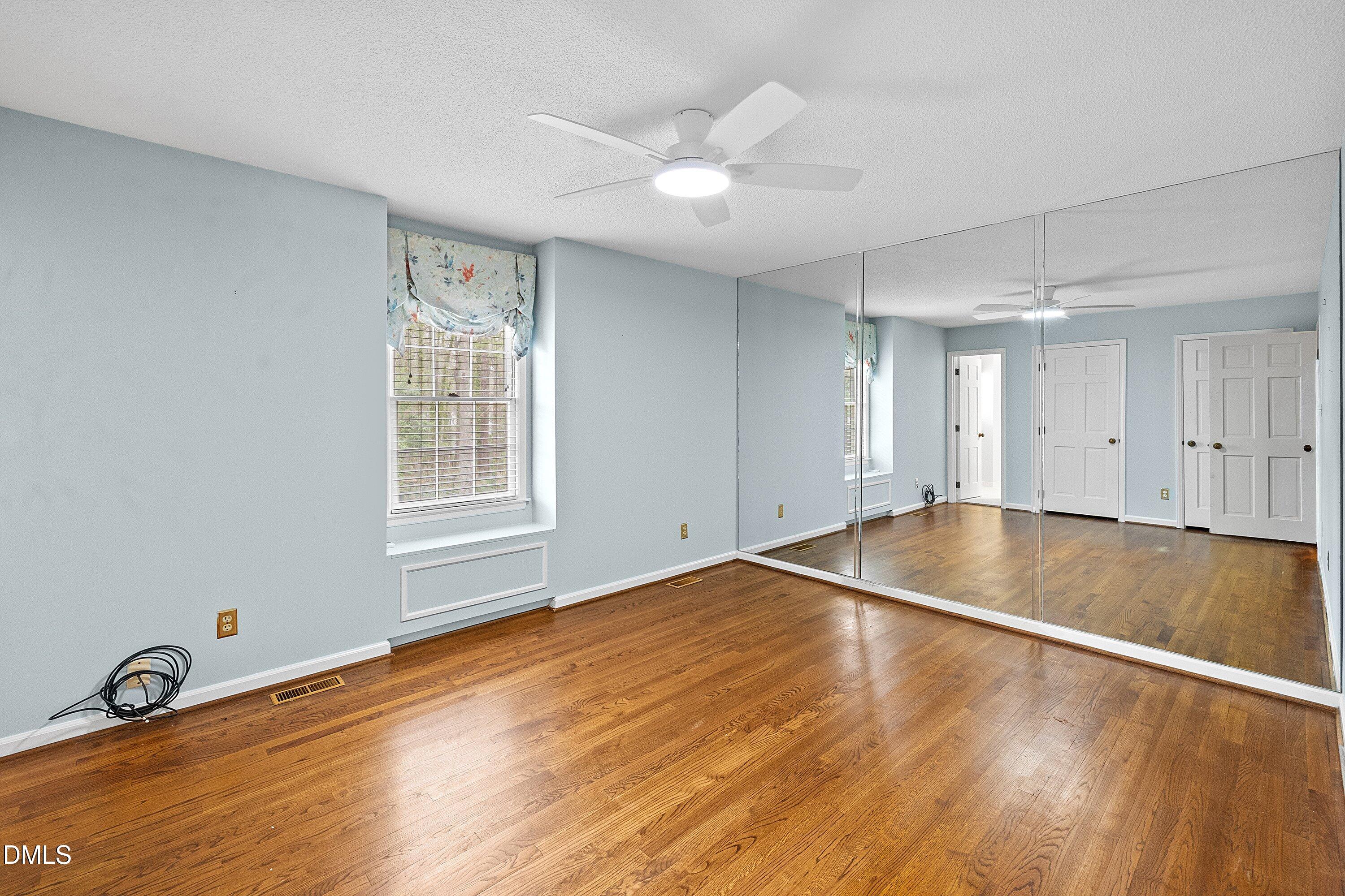1429 Falls Church Road Raleigh, NC 27609 - Photo 40 of 60 a view of empty room with wooden floor and fan