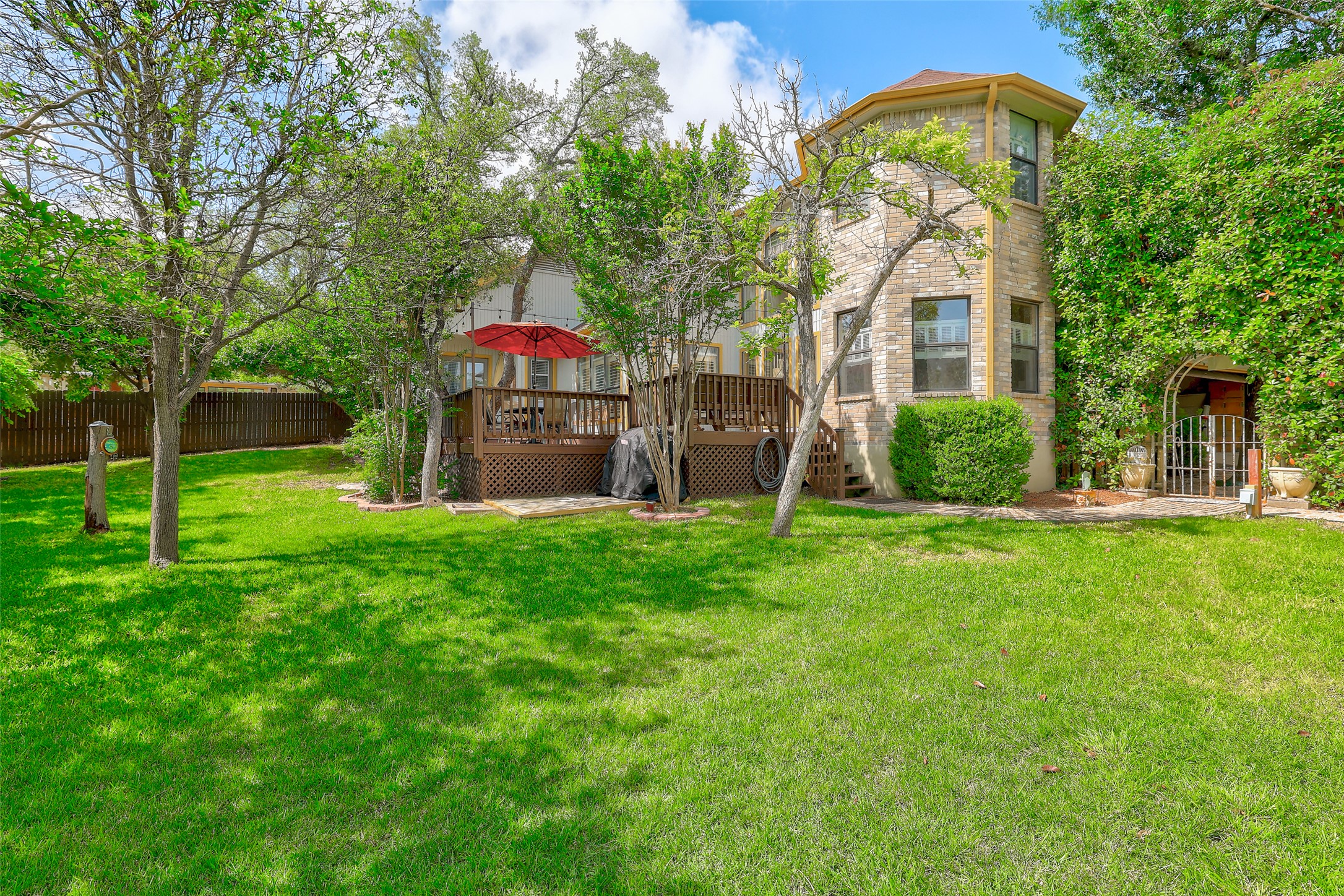 110 South Ridge Circle Georgetown, TX 78628 - Photo 35 of 37 Expansive lawn area featuring a multi-level wood deck, a stone facade exterior, and mature perimeter landscaping